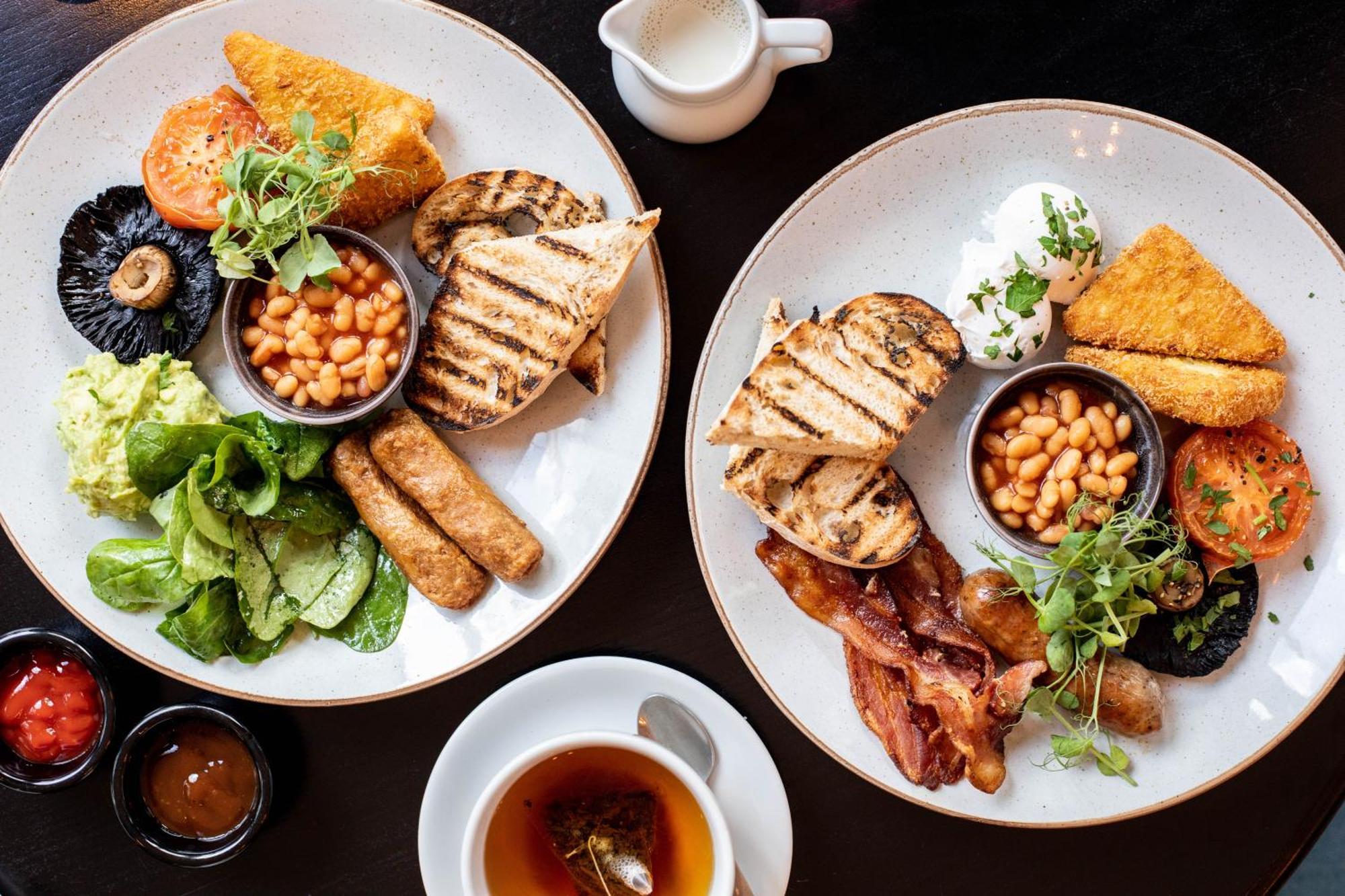 Citysuites 2 Aparthotel Manchester Bagian luar foto The photo displays two plates of hearty breakfast items. Each plate includes:

- Grilled bread slices
- Grilled sausages
- Baked beans served in a small bowl
- Fresh salad with greens
- A slice of tomato
- A piece of grilled mushroom
- Crispy bacon s